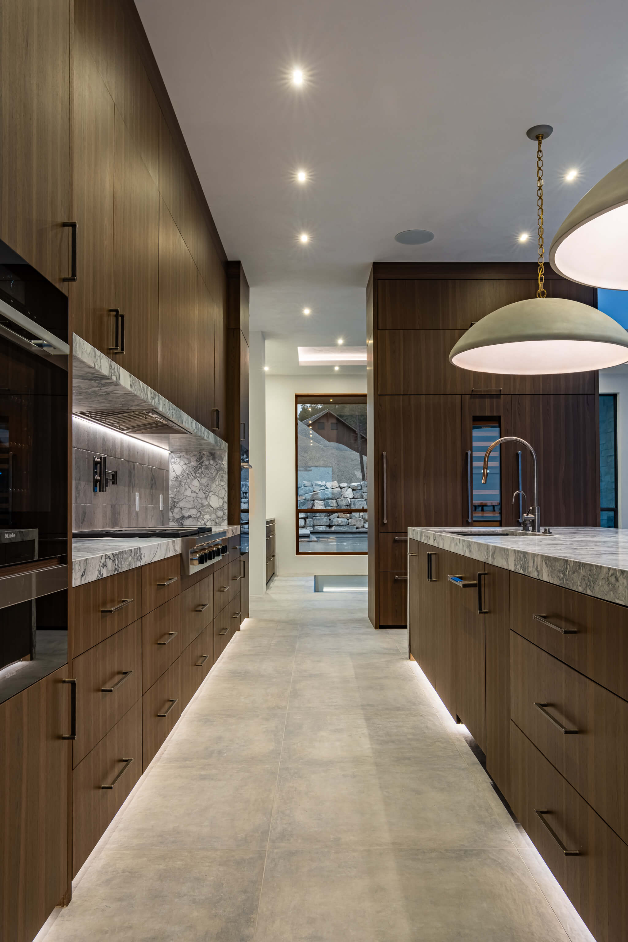 Modern kitchen with a stainless steel gas stove, black cabinetry, a marble countertop, and wooden ceiling and floor.