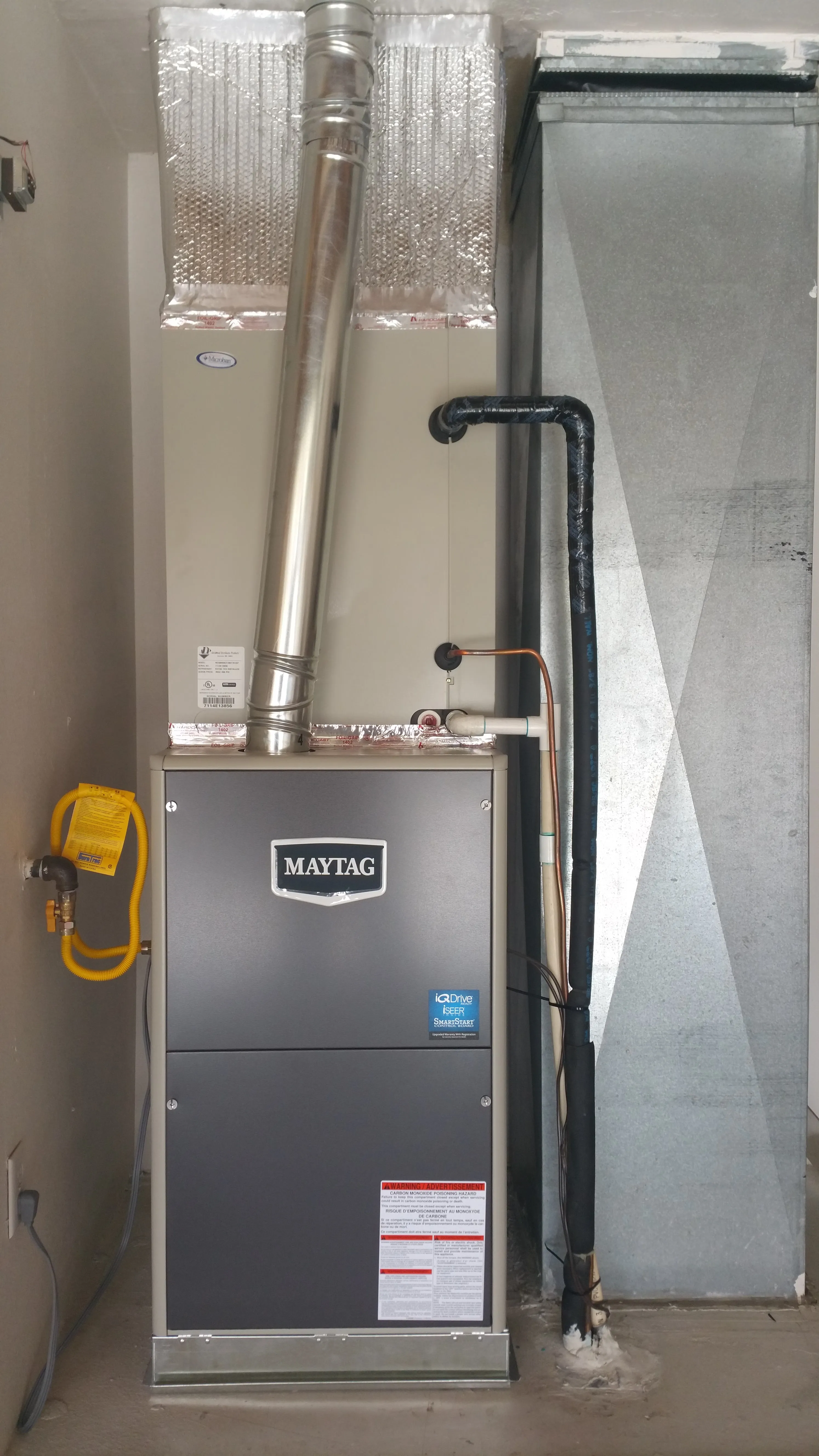 Maytag furnace installed in a residential setting with ventilation and gas connections.