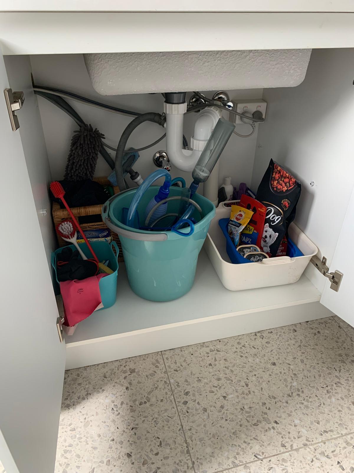Under-sink storage with cleaning supplies, brushes, and dog products