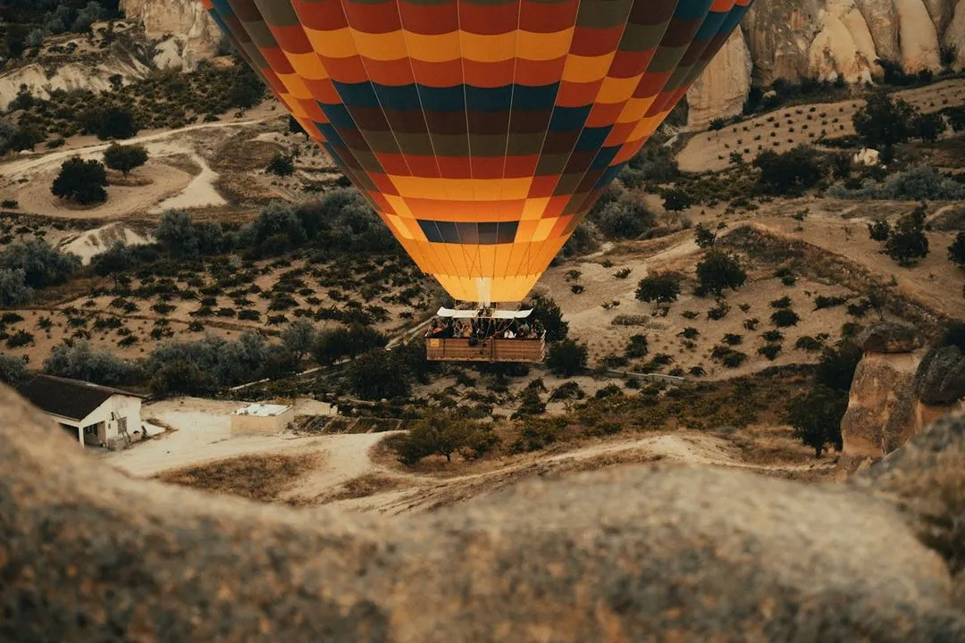 A hot air balloon flying over a mountain range.
