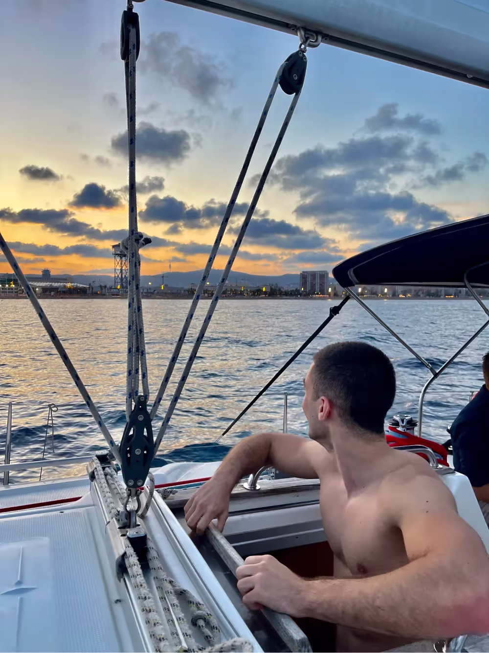 a young person watching sunset on a boat in barcelona