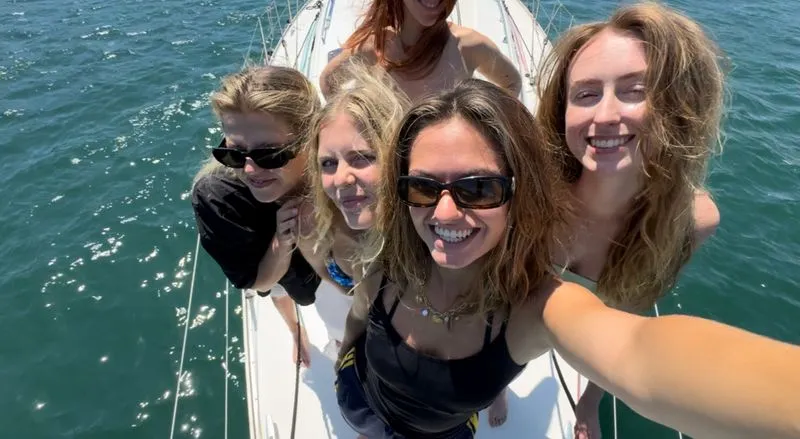 Chilling on deck under the sun with drinks on a bachelorette boat trip