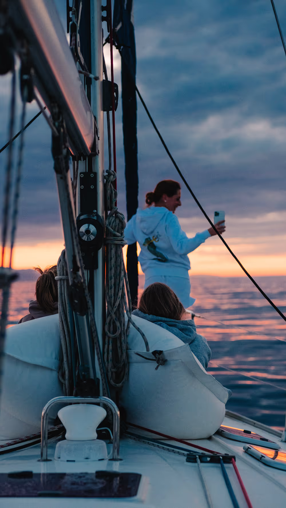 Couple enjoying sunrise Barcelona views from a sailboat deck