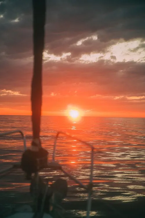 the sun rising in Barcelona watching it from a boat