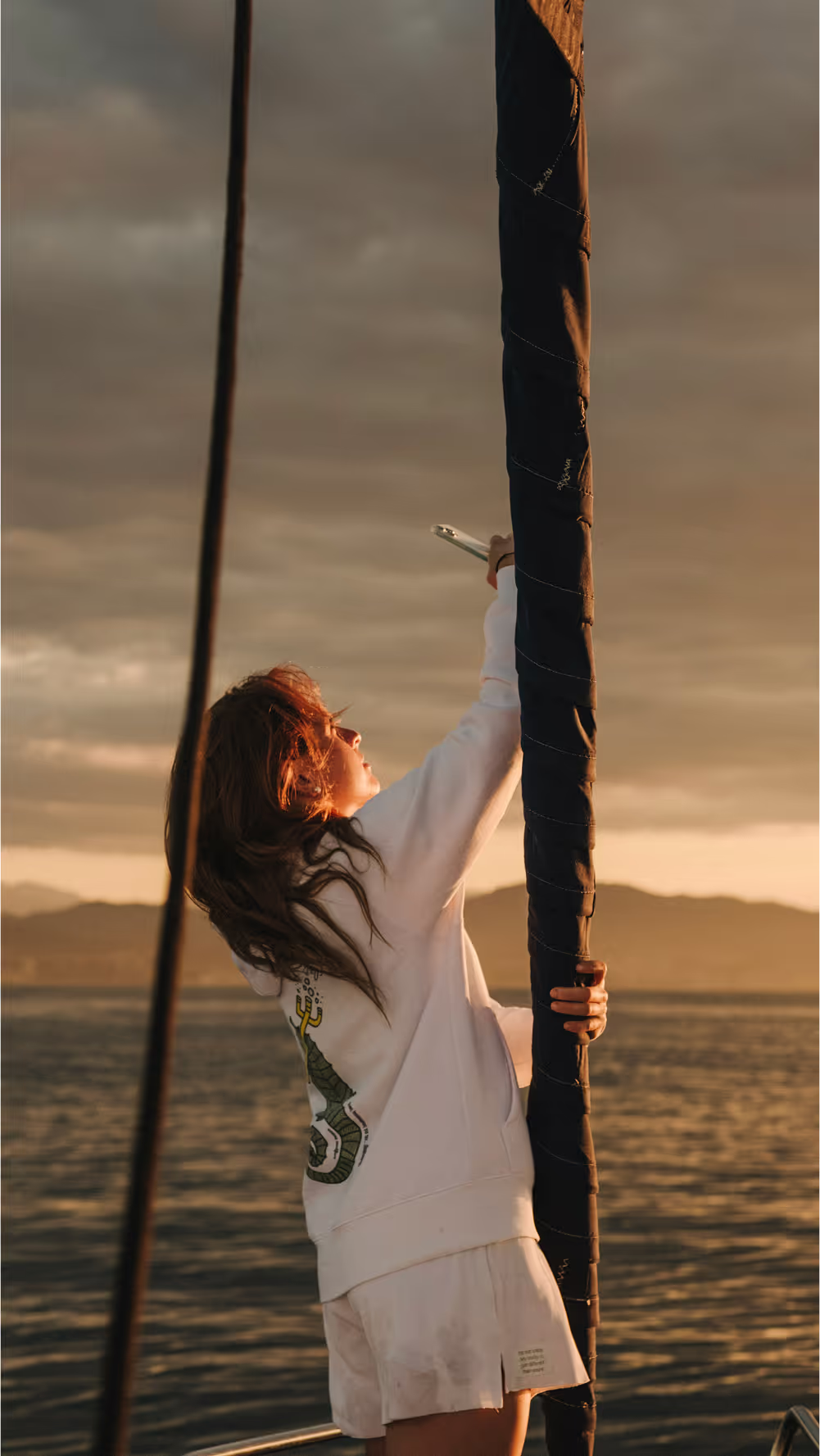 Guests sipping drinks on a sailboat under the Barcelona sunrise