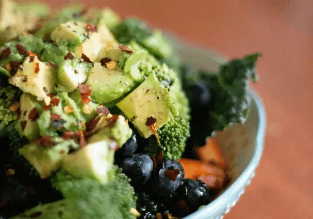 Eine nahrhafte Schüssel mit frischem Grün und Getreide, die Ernährungsstrategien zur komplexen Kontrolle der Gewichtsabnahme veranschaulicht.