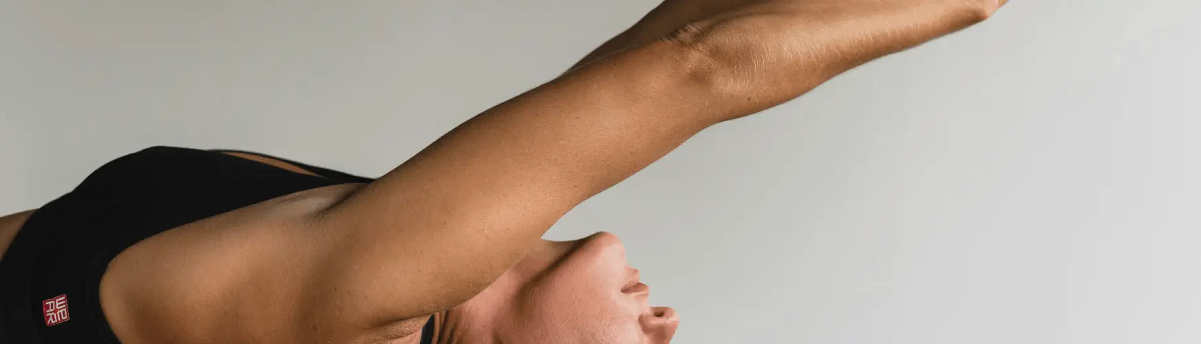 Eine Frau in schwarzer Sportkleidung beim Training, die körperliche Vitalität durch Hormonersatztherapie repräsentiert.