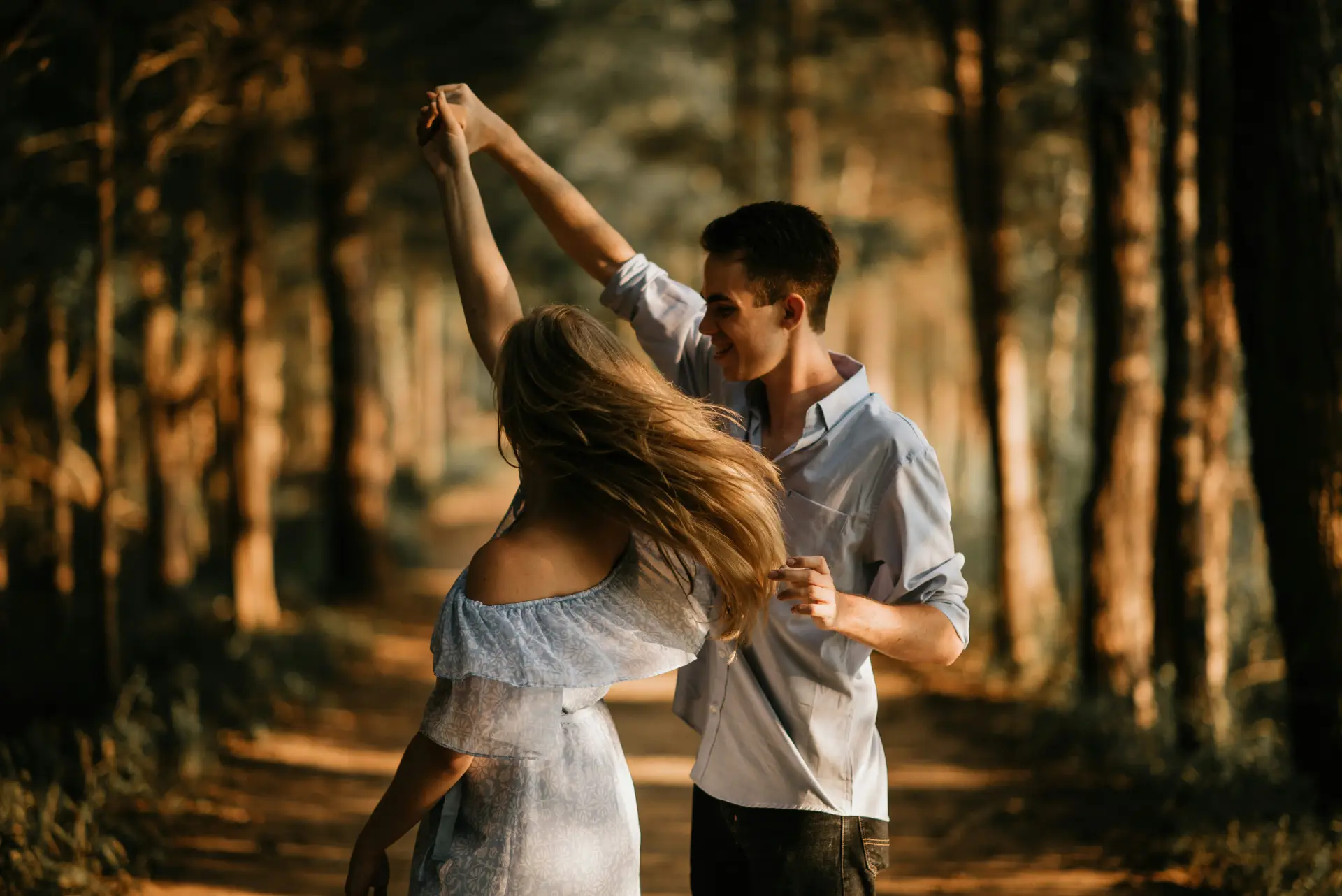 A man and woman dancing together in a garden, illustrating physical vitality, healthy aging and sexual health