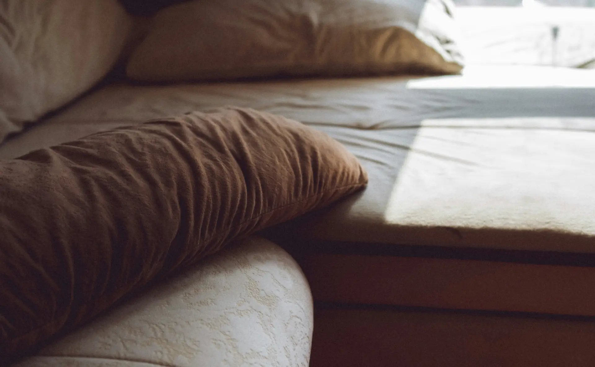 Eine Nahaufnahme der sich berührenden Hände eines Paares auf einem Holztisch, die emotionale Verbundenheit, Unterstützung und gute sexuelle Gesundheit betont.