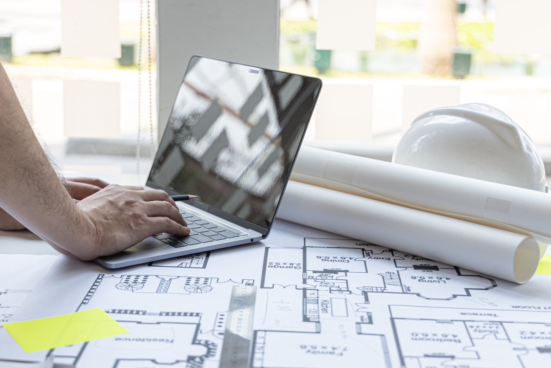 Architekt BRJ-Studio pracujący nad nowoczesnym projektem domu na laptopie