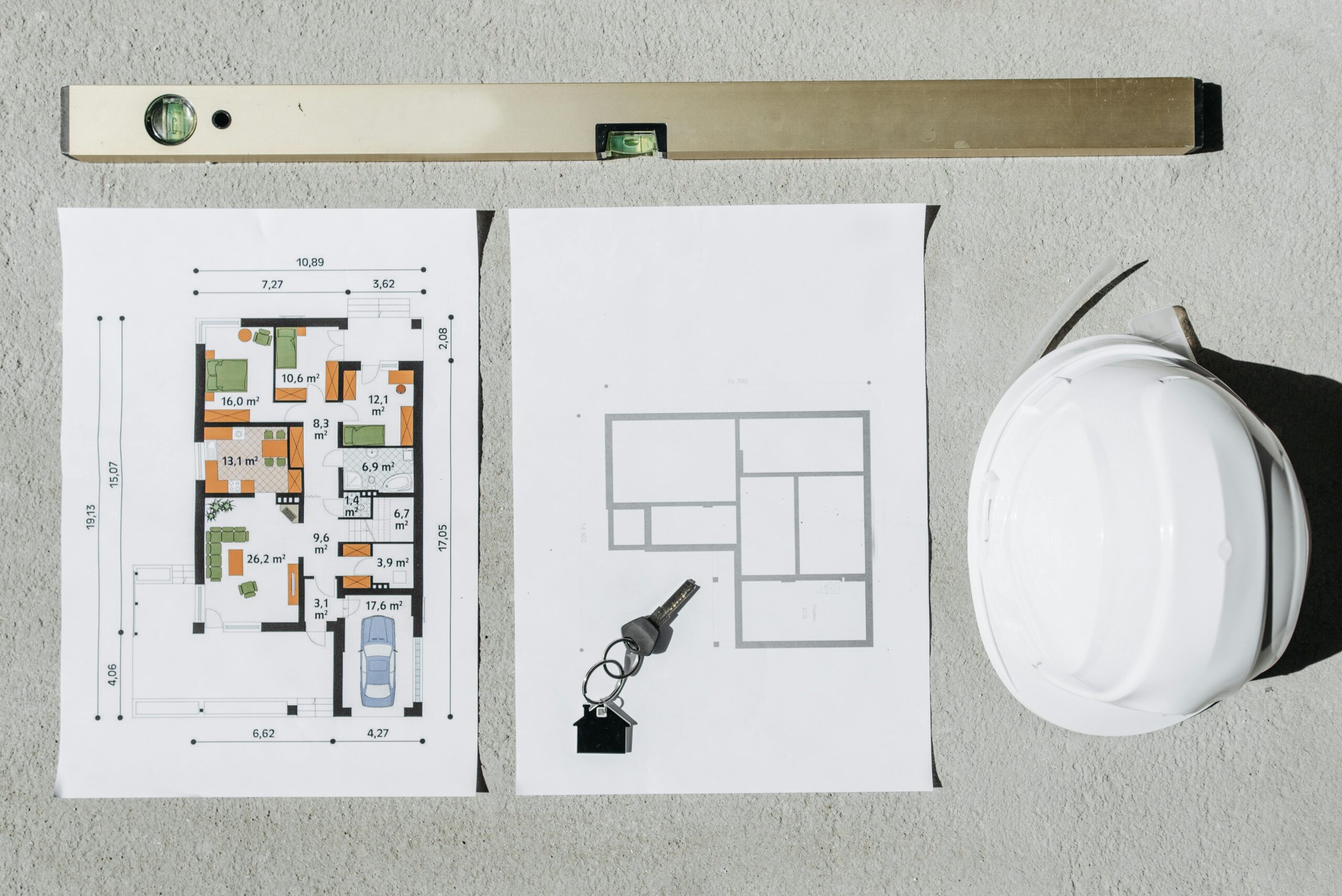 Rzuty projektu gotowego domu, kask budowlany i klucze - adaptacja architektoniczna BRJ-Studio