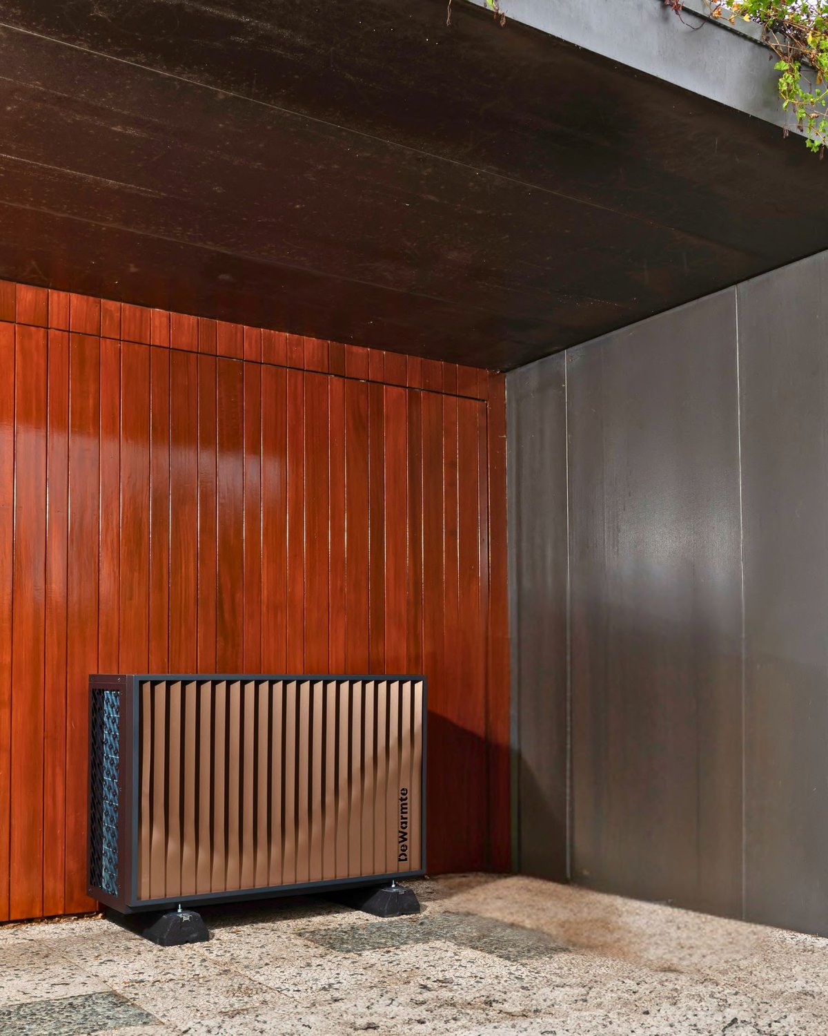 DeWarmte Pomp MP warmtepomp onder een carport met houten wand