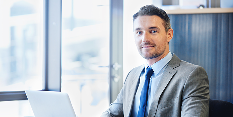 Smiling Man Working on Laptop