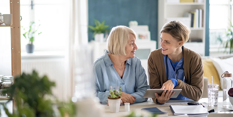 Woman shows another a patient portal on a tablet