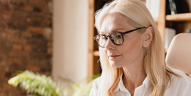 Woman in Button Down Shirt Using Laptop