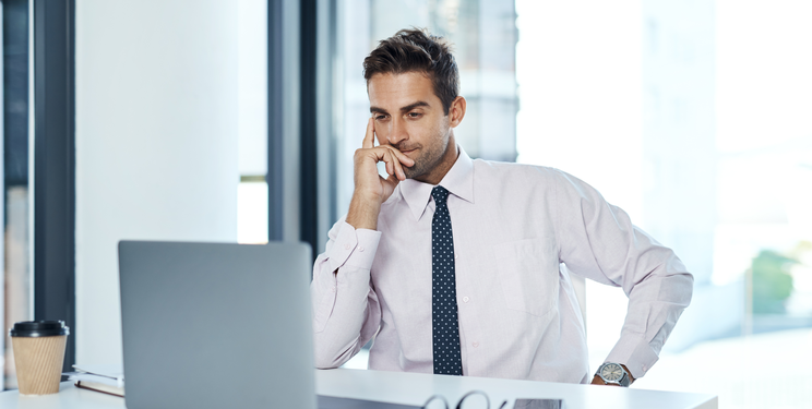 Healthcare administrator reviewing patient account information on a laptop