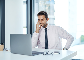 Healthcare administrator reviewing patient account information on a laptop