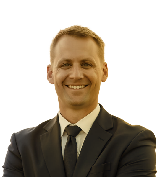 Portrait of Aaron Kennelly smiling in a business suit.