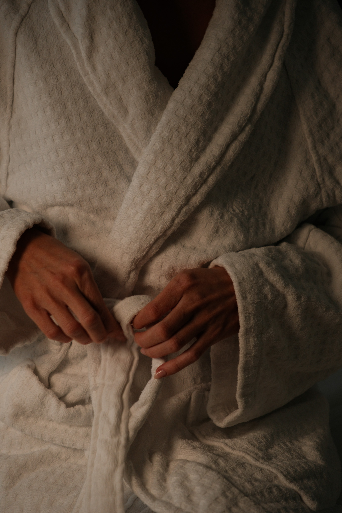 Person in bed reading The Japan Times newspaper with a breakfast table in the foreground holding orange juice, coffee, and plates of food.