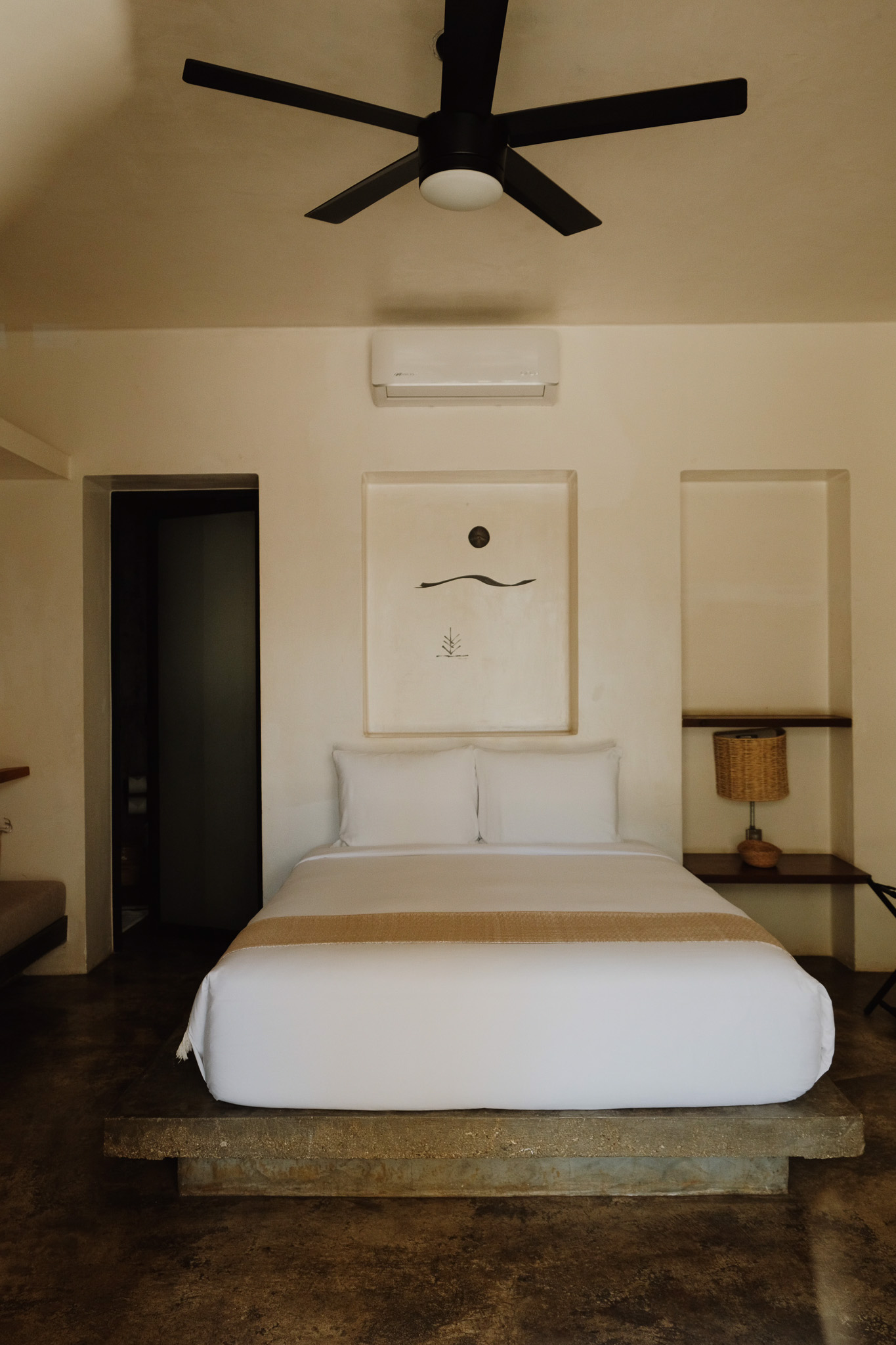 Cozy restaurant interior with floral wallpaper, cushioned chairs, set tables, and a blurred pink cocktail in the foreground.