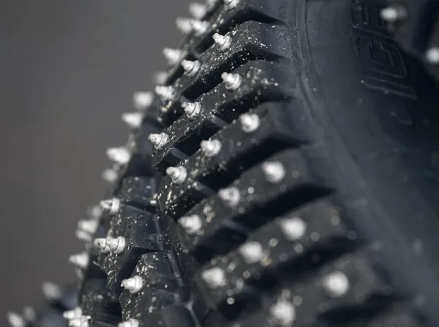 Nahaufnahme eines Winterreifens mit Spikes
