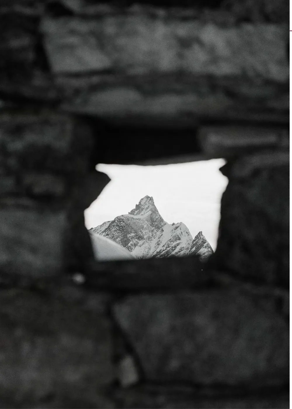 Blick durch eine Öffnung in einer Steinmauer auf das Matterhorn