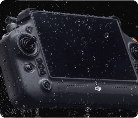 Black DJI remote controller with water droplets on its screen and buttons against a black background.