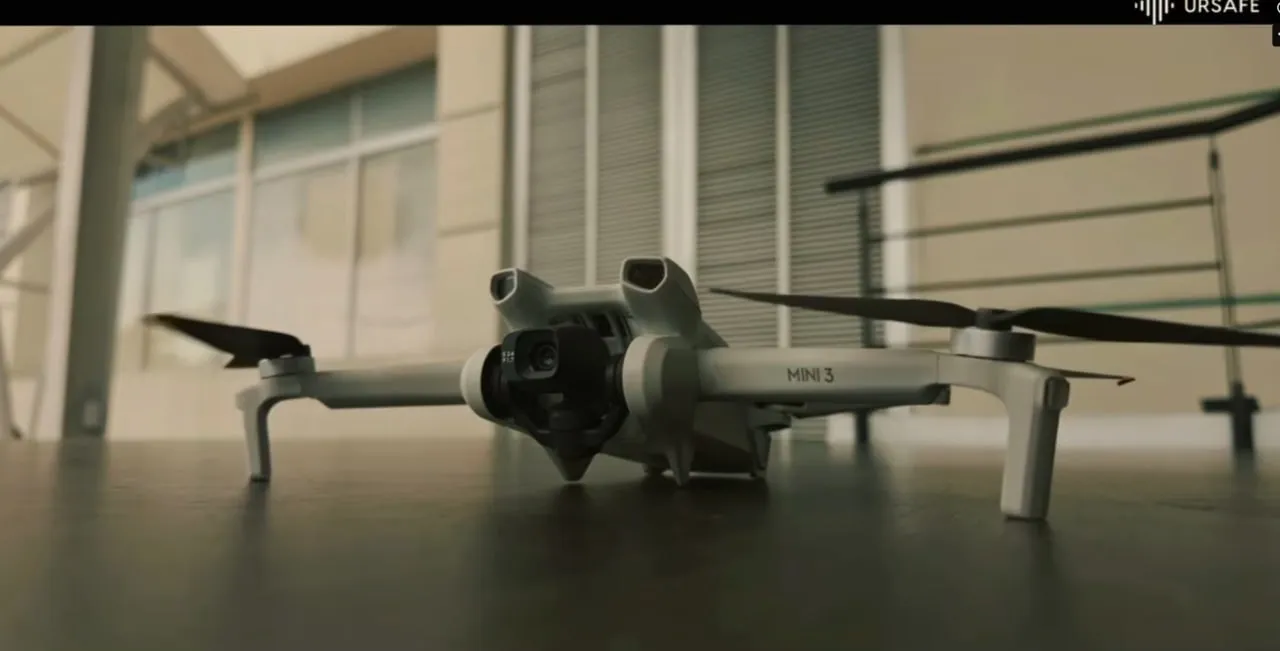 Close-up of a DJI Mini 3 drone with camera and propellers placed on a table indoors.