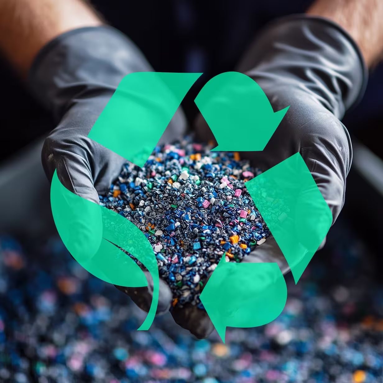 Hands wearing black gloves holding small colorful plastic pellets with a green recycling symbol overlay.