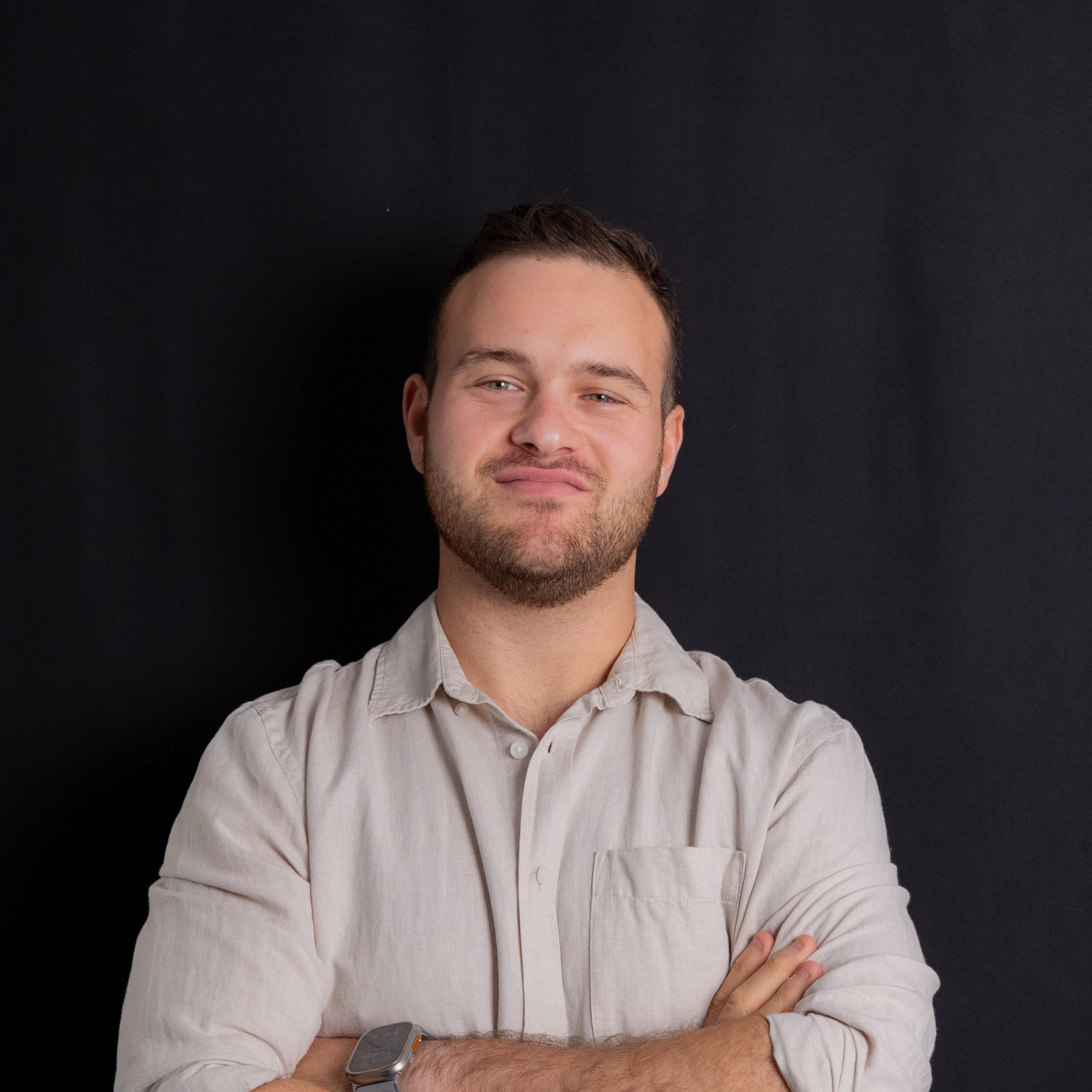 Headshot of Company Founder, Roy Gelbart, smiling in front of a black background