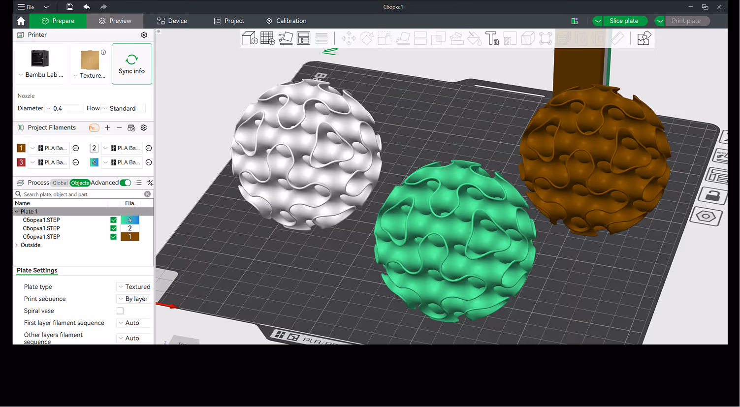 3D-printing software interface showing three textured spherical models in white, green, and brown on a virtual print bed grid.