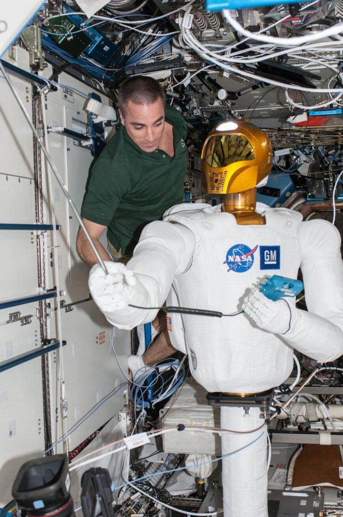 NASA astronaut Chris Cassidy works with Robonaut 2, the humanoid robot 