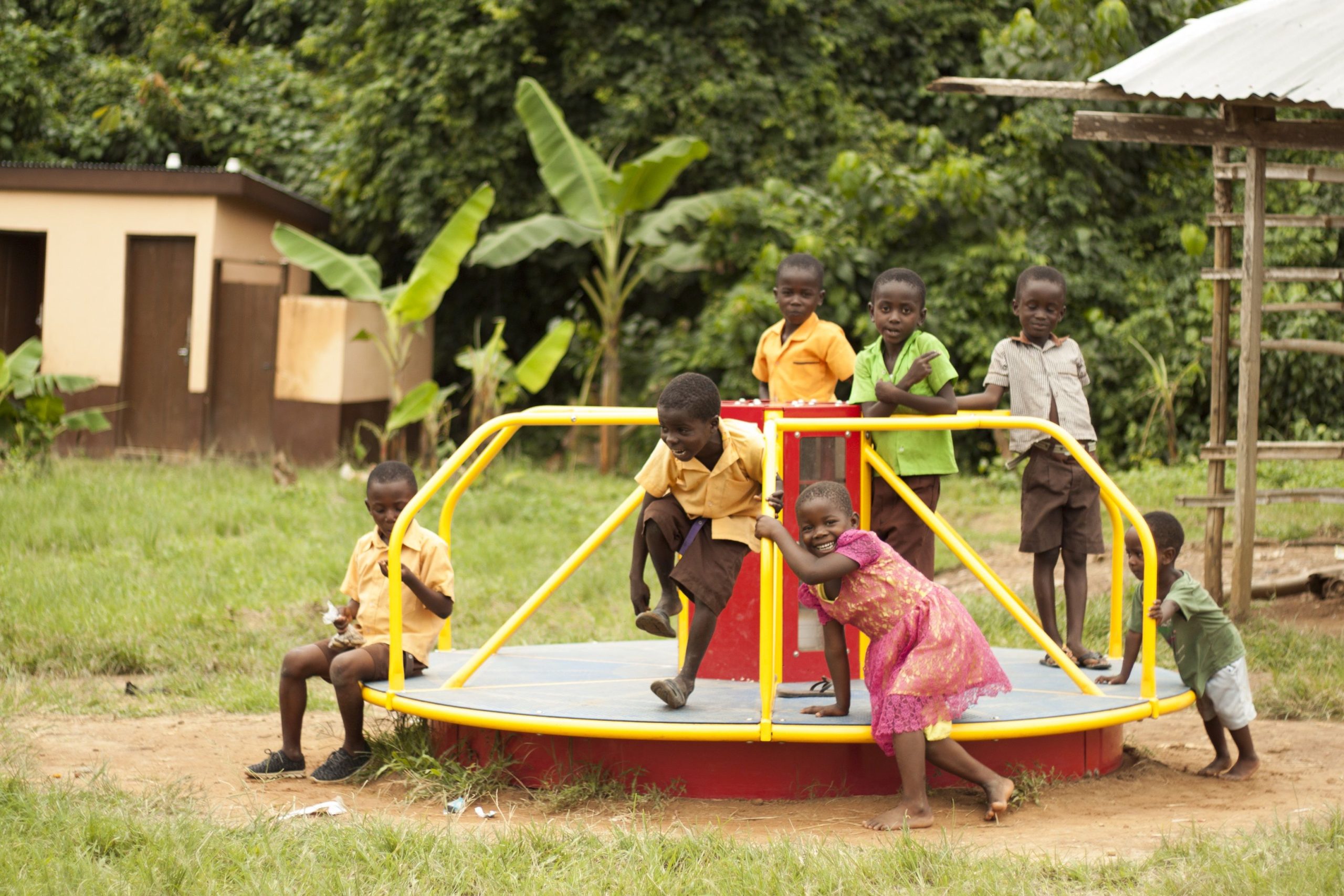 Kids in Ghana playing on merry-go-rounds known as "whirls” that generate power for portable lanterns