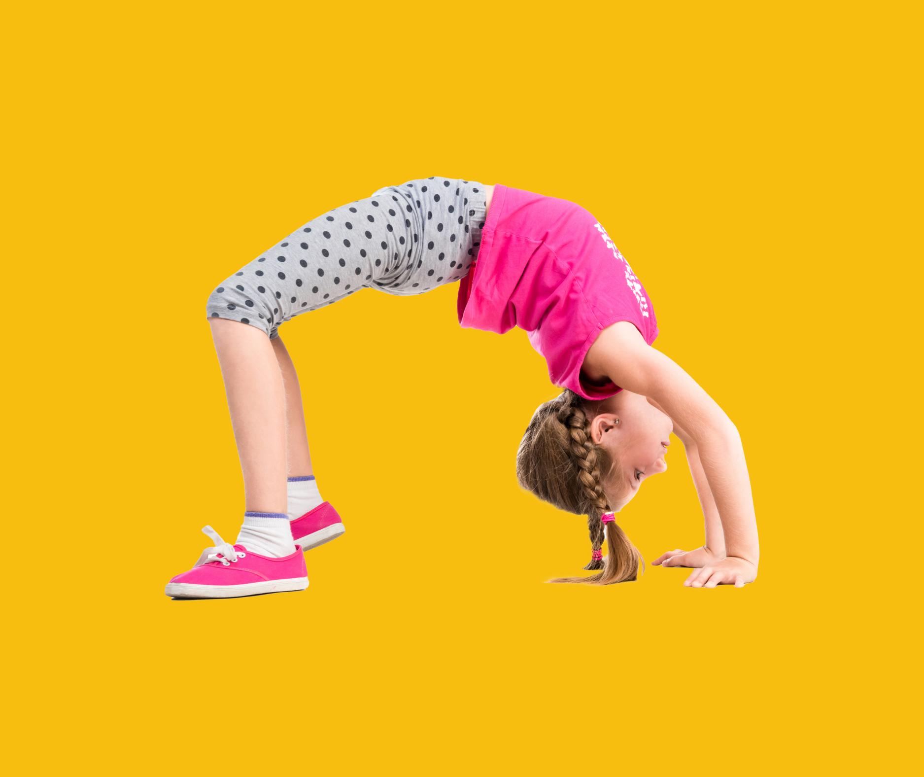 Young girl in pink top and polka-dot leggings doing a backbend on a yellow background.