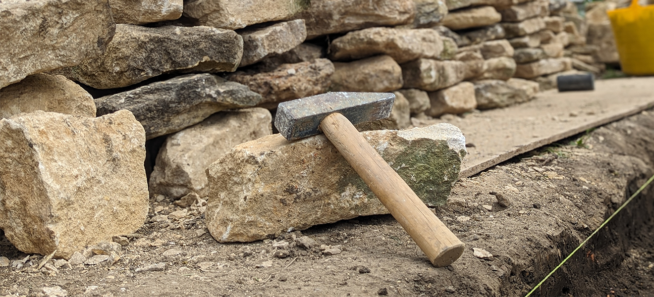 A dry stone walling hammer has a pointed 'chisel' end on one side and flat square head on the other. Perfect for dressing stone when laying.