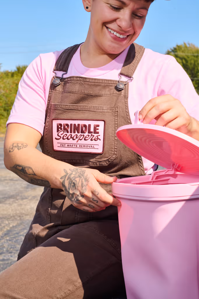 pooper scooper technician with a pink garbage can