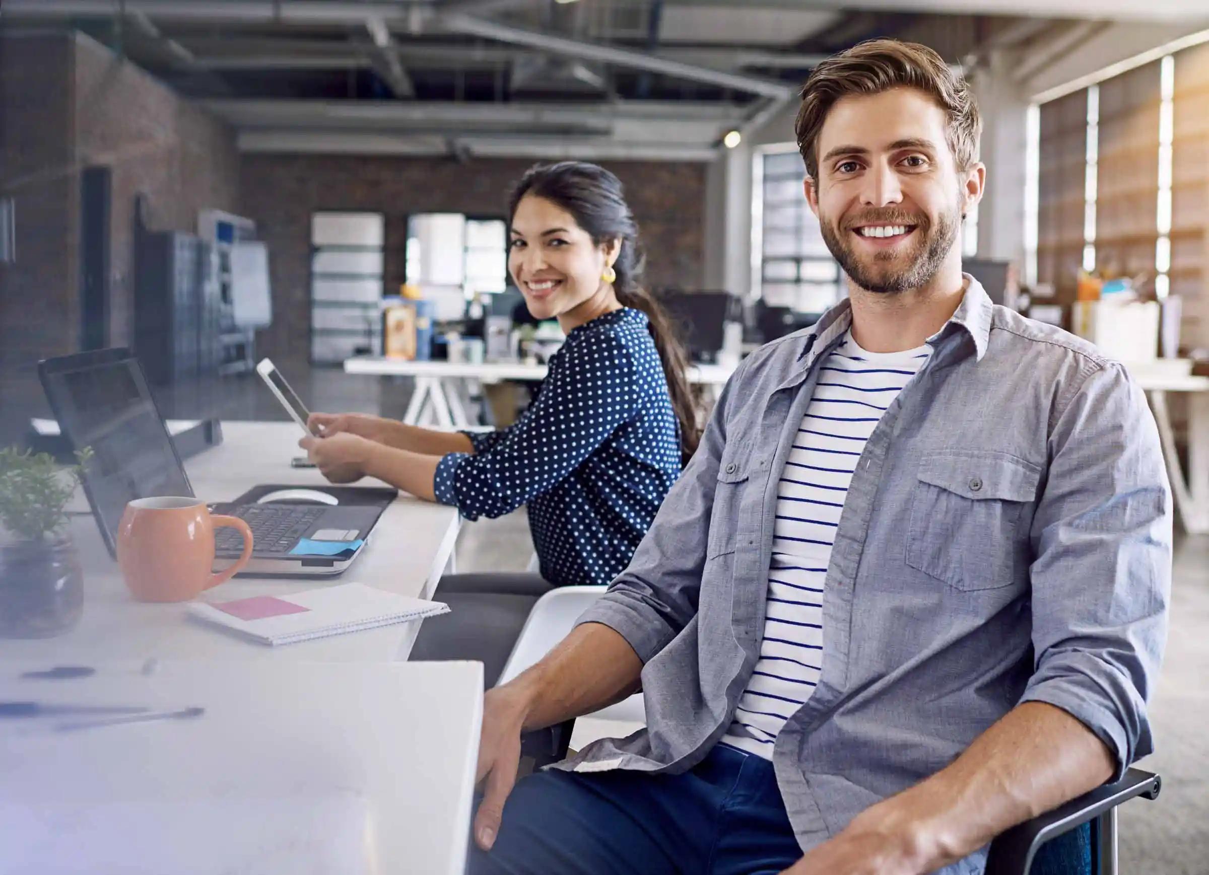 Creative agency owners smiling during a professional shoot, symbolizing growth-focused small business clients.