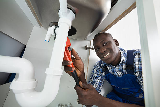 Professional plumber fixing pipes in an Accra home