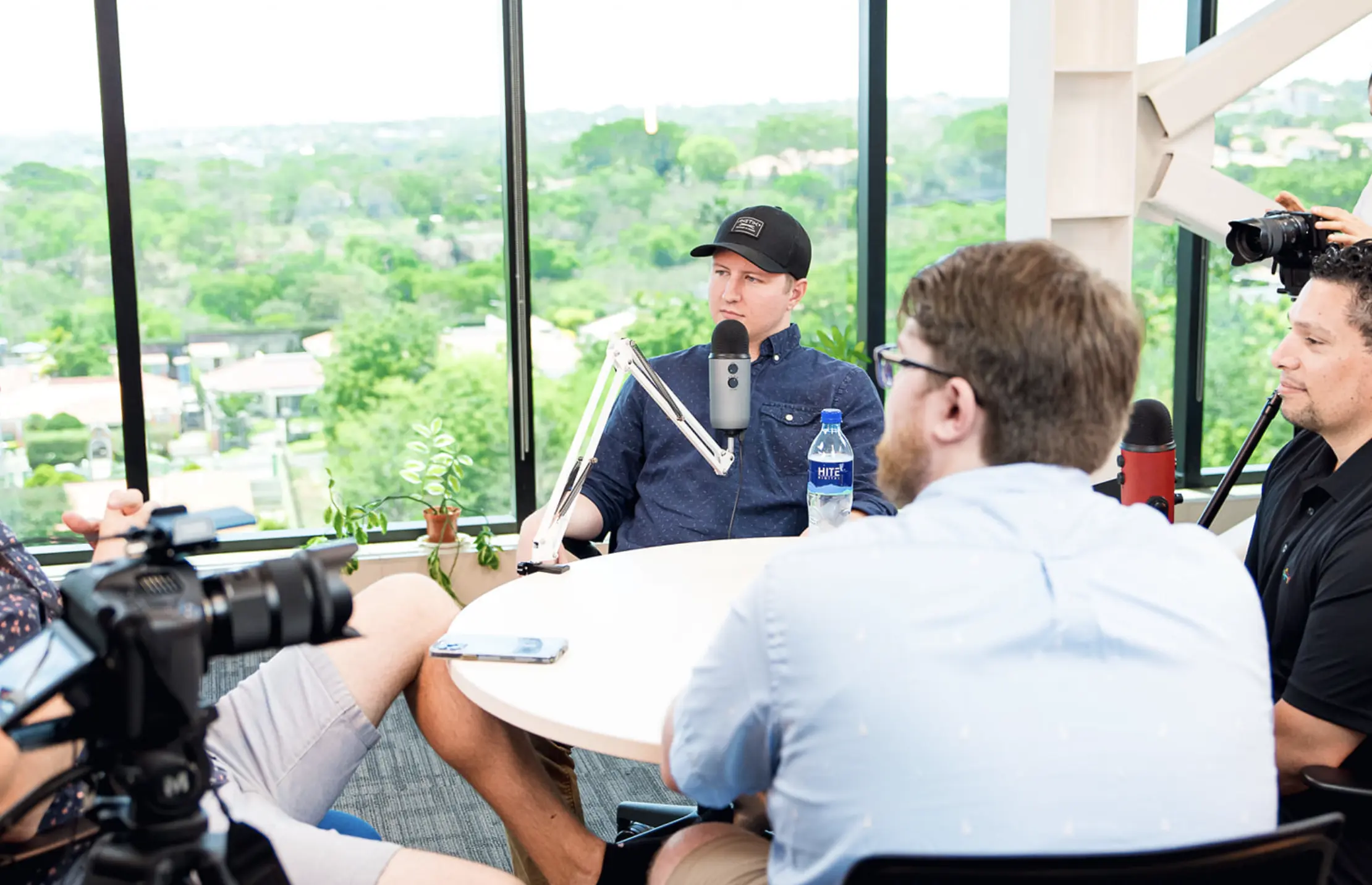 A team sitting at a table having a podcast over marketing.