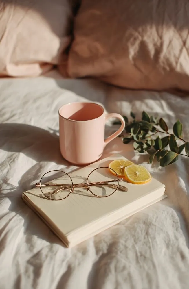 journal and cup on a bed