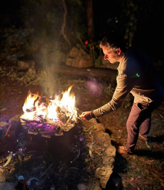Serge tending a fire