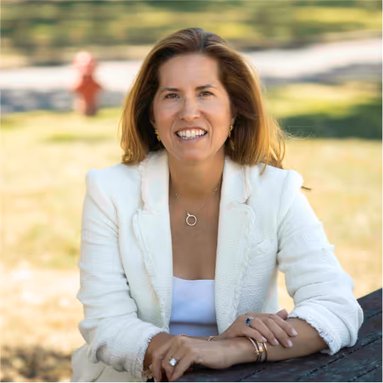 Melissa Manice smiling while sitting on a bench.