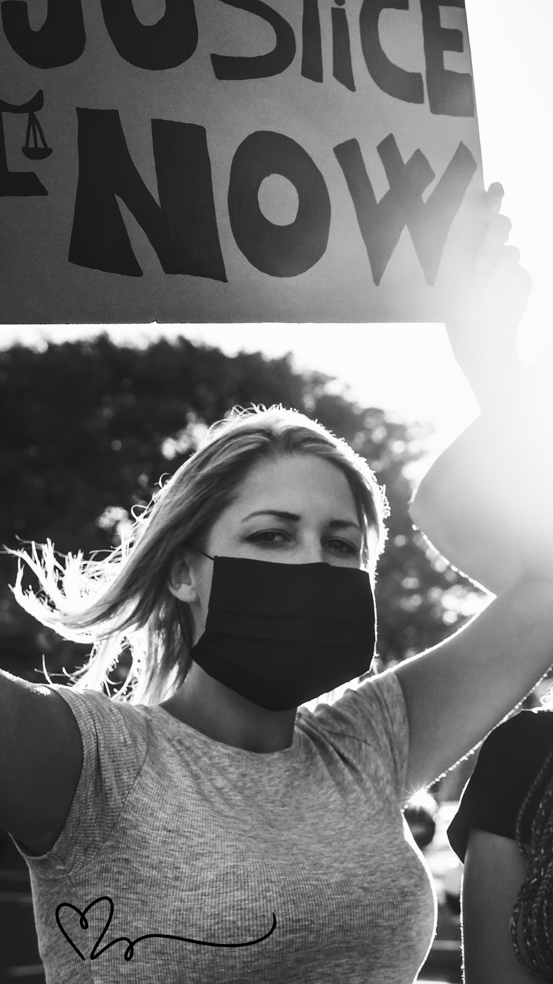 A woman holding a banner saying 'Justice Now' 
