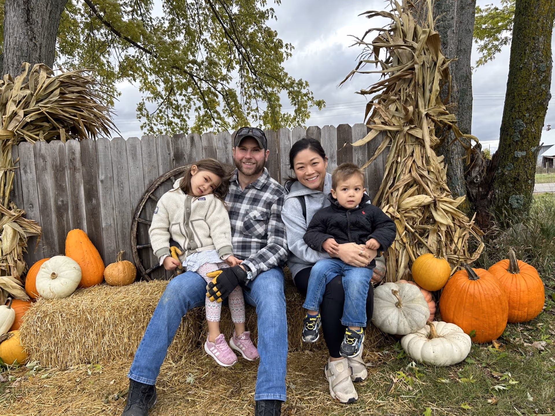 Chris Steward with family on bale of hay at fall festival