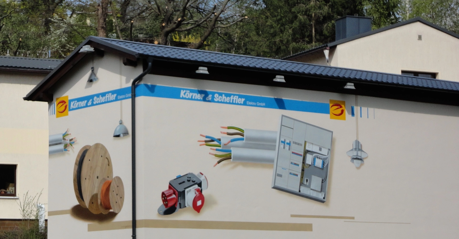 Firmengebäude der Körner & Scheffler Elektro GmbH in Wilkau-Haßlau bei Zwickau mit Wandgestaltung zu Elektroinstallationen – Symbol für Tradition und Regionalität.