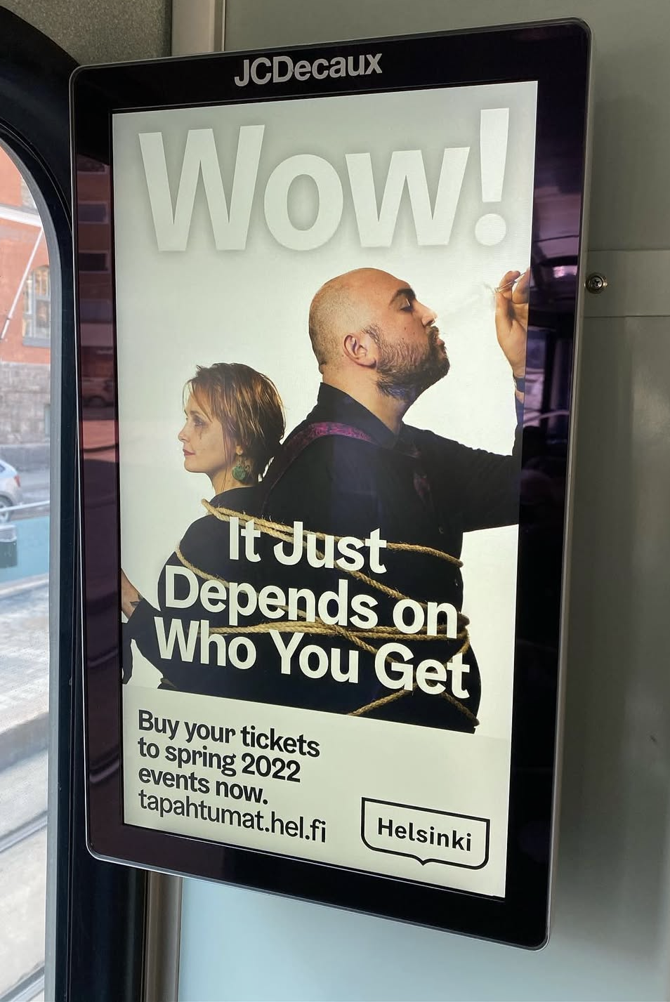 Digital ad showing a man and woman tied together with rope, text reads 'Wow! It Just Depends on Who You Get' and information about buying tickets for spring 2022 events in Helsinki.
