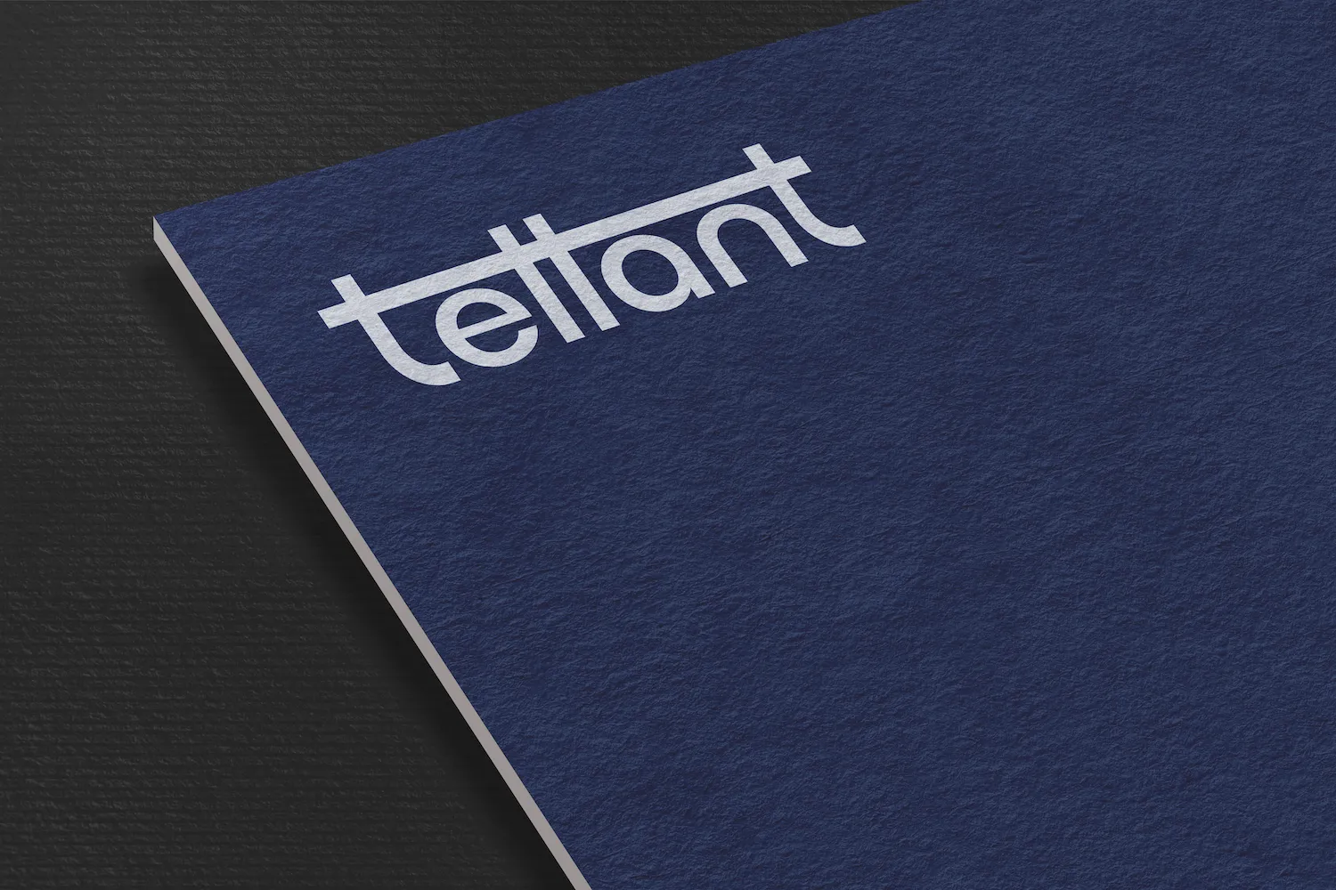 Blue textured card with the word 'tellant' in white lowercase letters and a horizontal line crossing the top of the letters.