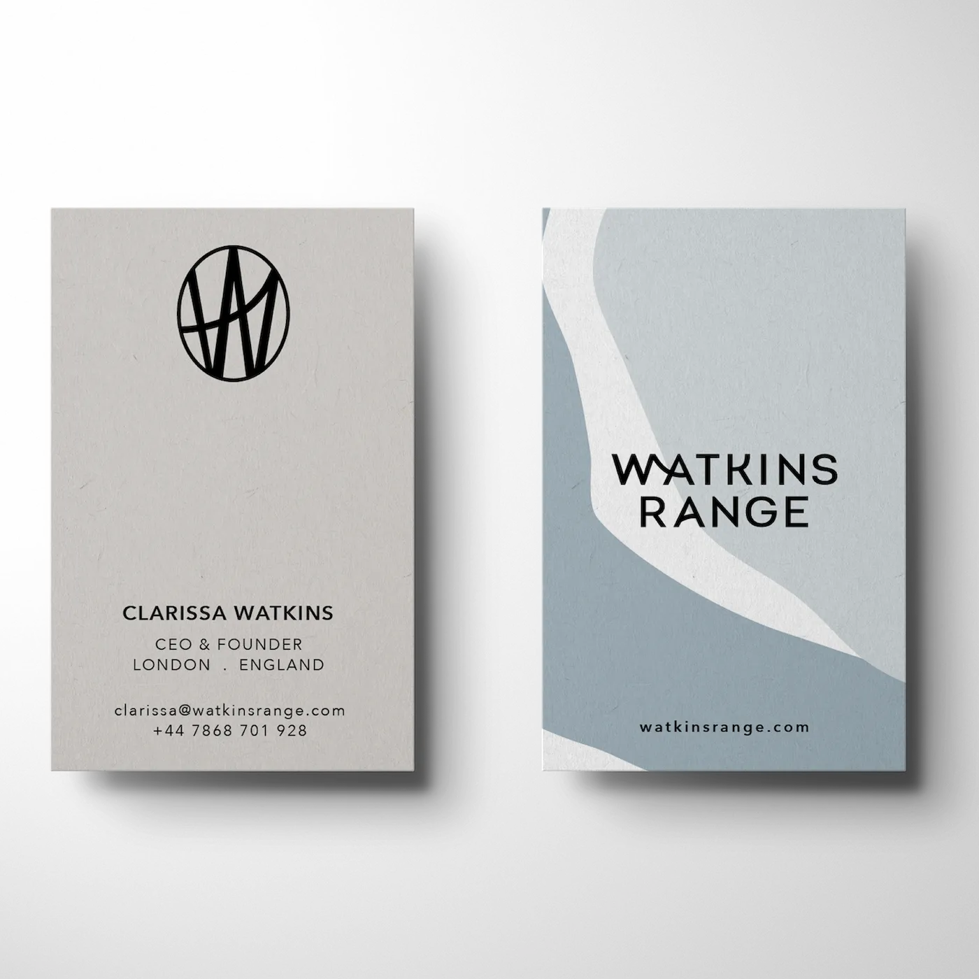 Two business cards side by side; left card with Clarissa Watkins' contact info and black circular logo, right card with abstract blue and white design and Watkins Range branding.
