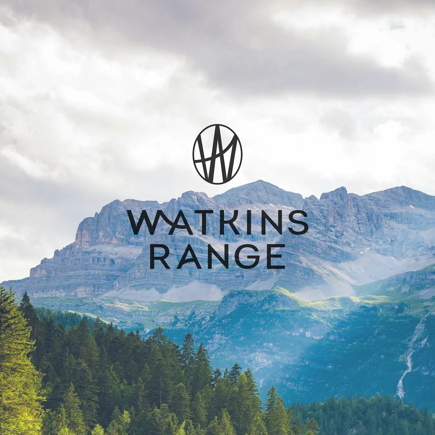 Mountain range with forested hills under a cloudy sky, overlaid with Watkins Range logo and text.