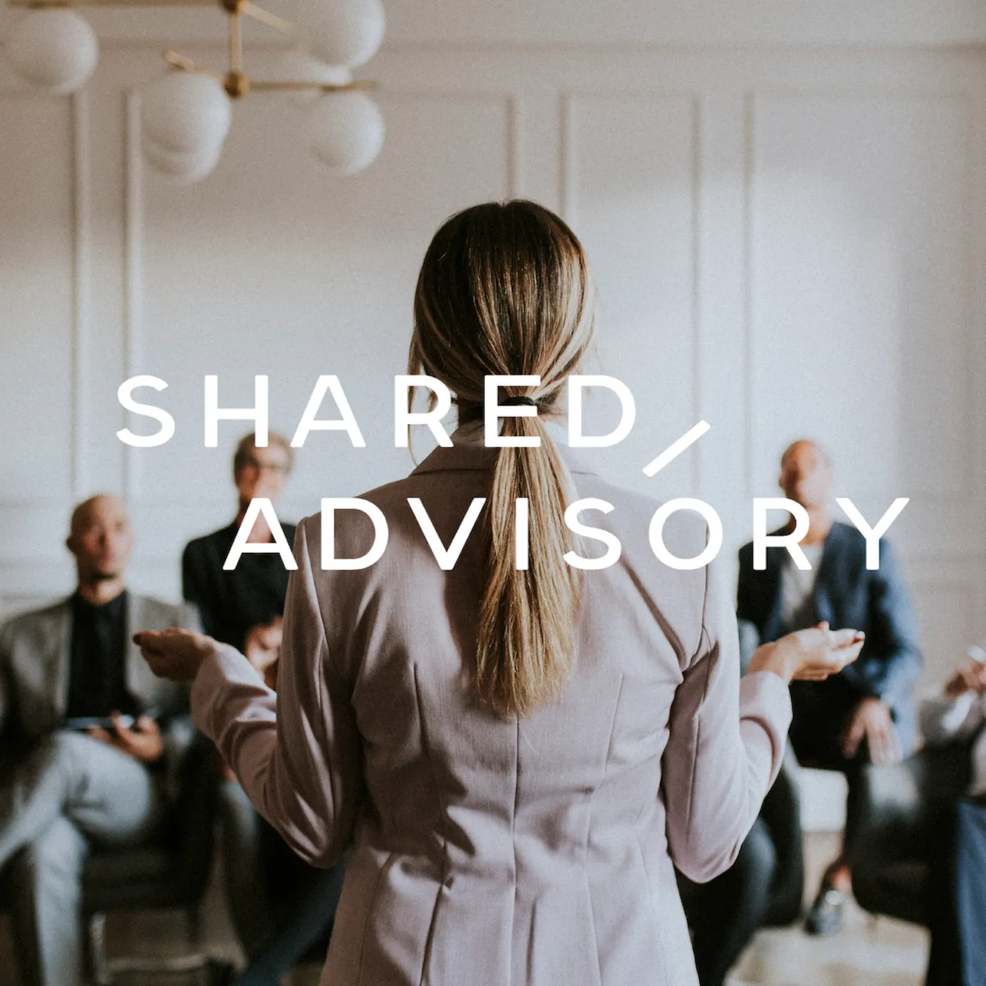 Businesswoman leading a meeting with a group of professionals seated in the background, with the text 'Shared Advisory' overlaid.